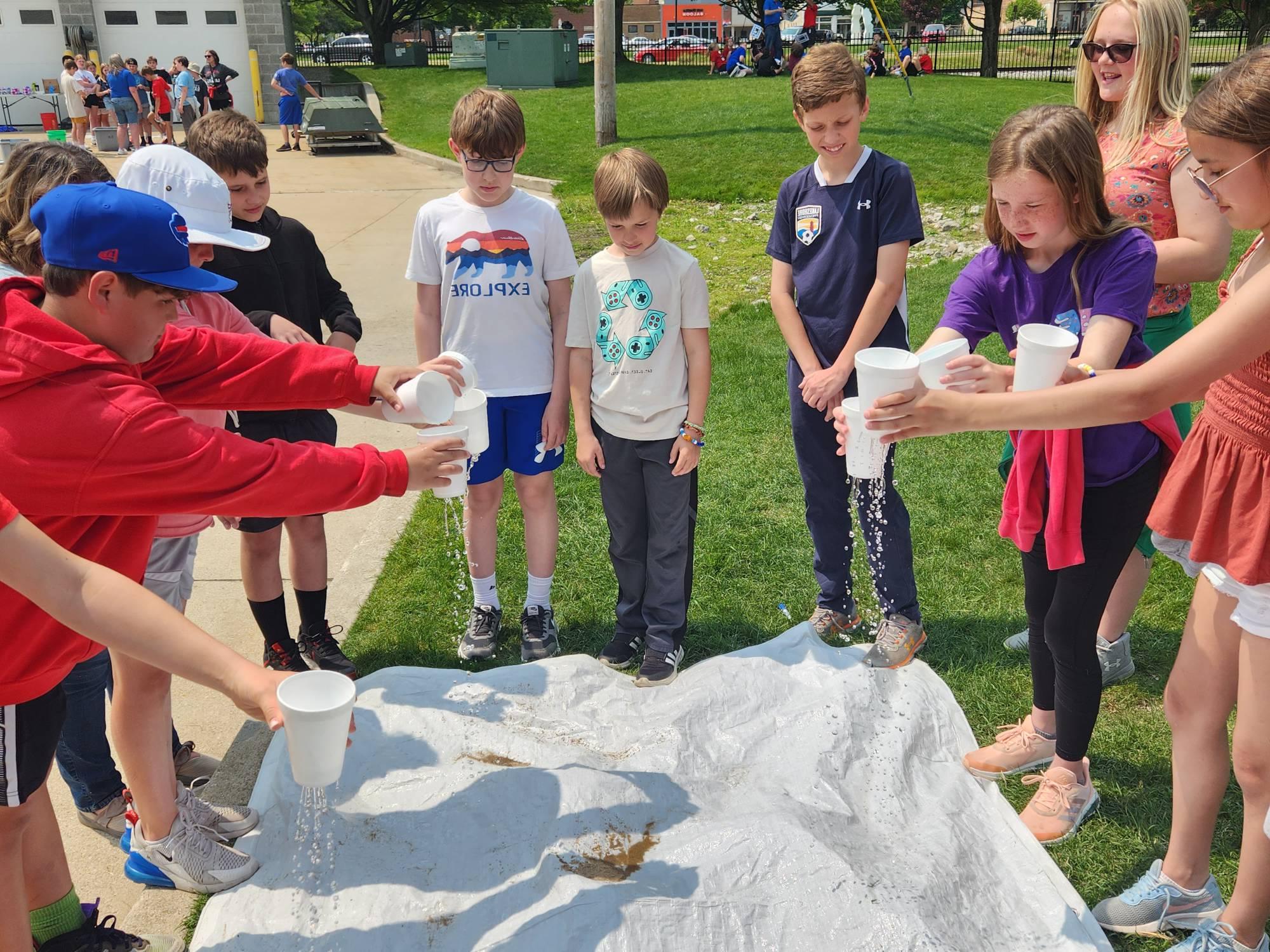 Students simulate a rainstorm over a model of a watershed during an AWRI landside program